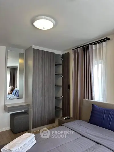Modern bedroom with sleek wardrobe and cozy bedding in a stylish apartment.