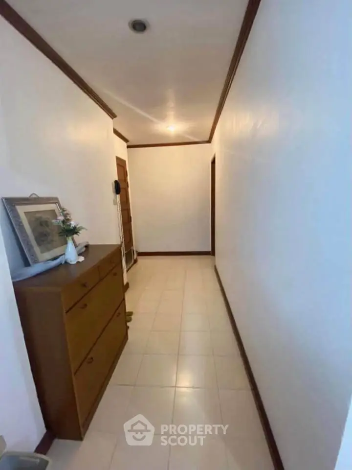 Spacious hallway with elegant wooden furniture and soft lighting, perfect for a welcoming entrance.