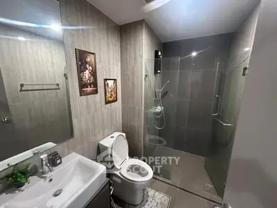 Modern bathroom with glass shower, sleek fixtures, and elegant decor.