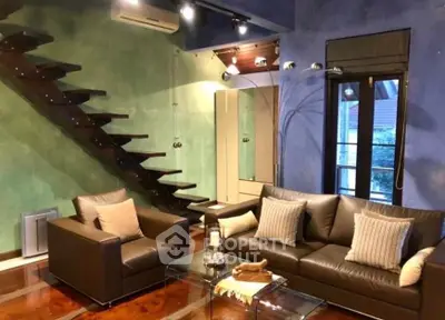 Stylish modern living room with unique staircase and cozy seating area