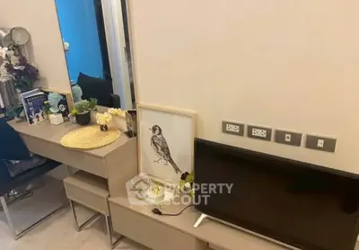 Modern living room with stylish decor and sleek furniture, featuring a TV and decorative elements.