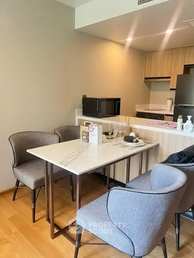Modern kitchen with dining area featuring sleek furniture and appliances in a stylish apartment.