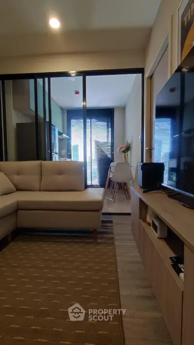 Modern living room with cozy sofa and open layout leading to dining area