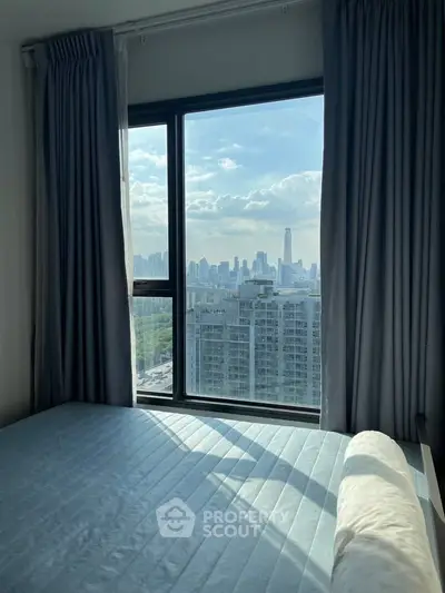 Stunning bedroom with panoramic city view from large window, perfect urban living.