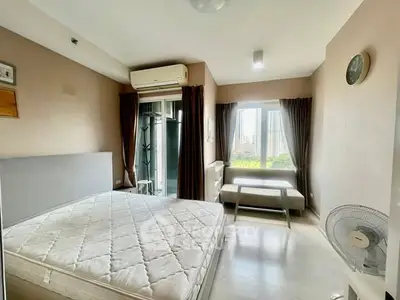 Spacious bedroom with large windows and modern furnishings in a stylish apartment.