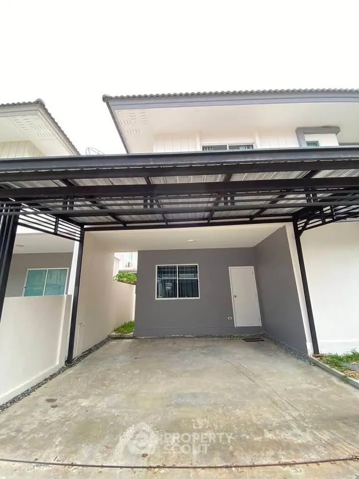 Modern two-story house with covered parking and sleek exterior design.