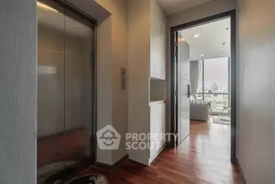 Modern apartment entrance with elevator access and view into living room