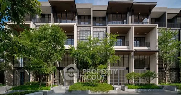 Modern townhouse exterior with lush greenery and large windows