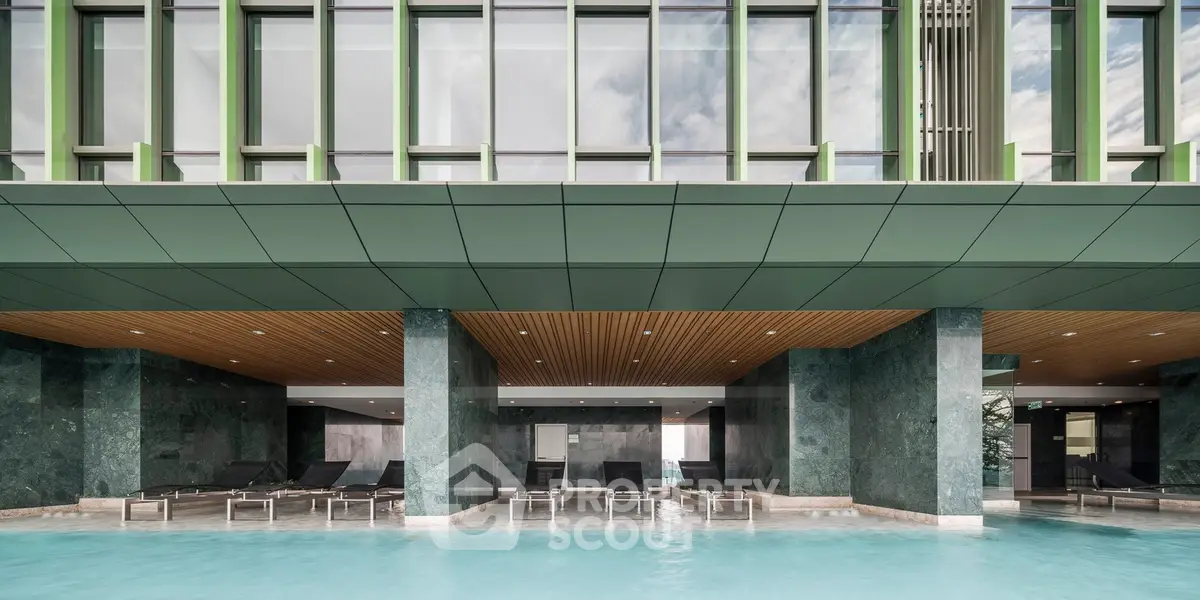 Luxurious modern building with poolside lounge area and sleek architectural design.