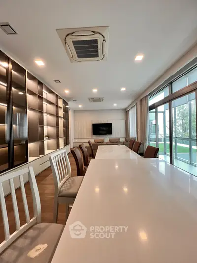 Spacious modern living room with large windows and elegant dining area