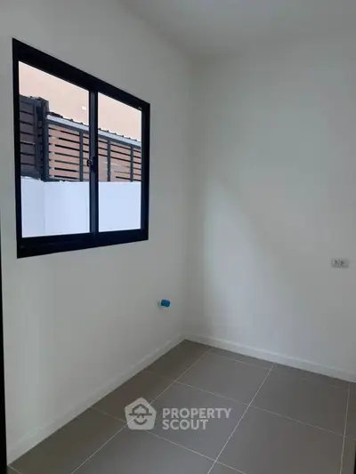 Minimalist empty room with window and tiled floor, ideal for customization.