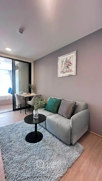 Modern living room with cozy sofa, stylish decor, and dining area in open-plan apartment.