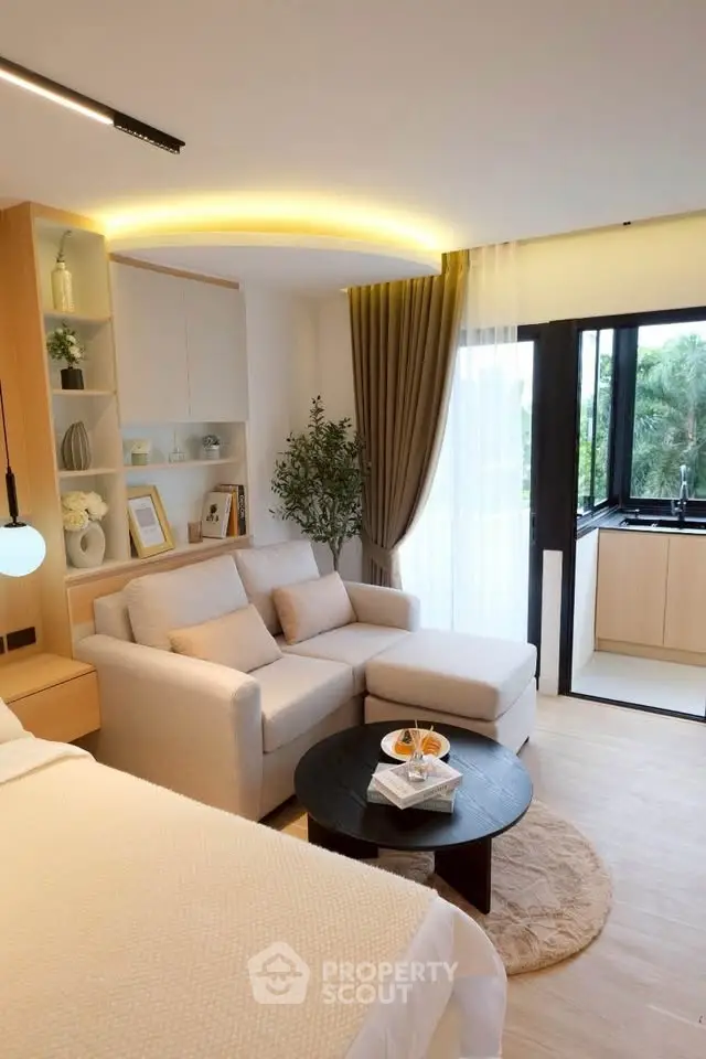 Modern studio apartment with cozy living area and open kitchen layout, featuring elegant decor and natural light.