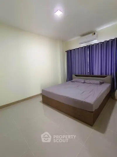 Spacious bedroom with modern bed and air conditioning, ideal for comfort and relaxation.