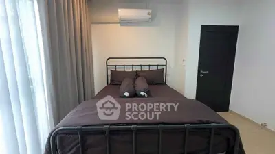 Modern bedroom with sleek metal bed frame and air conditioning, perfect for comfort and style.