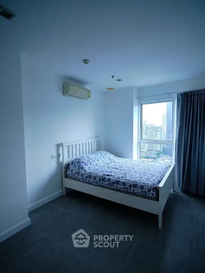 Modern bedroom with city view, featuring minimalist decor and large window for natural light.
