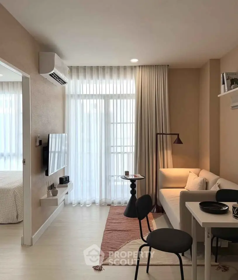 Modern living room with cozy sofa, wall-mounted TV, and elegant decor in a stylish apartment.