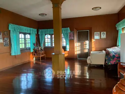 Spacious wooden living room with natural light and traditional decor.
