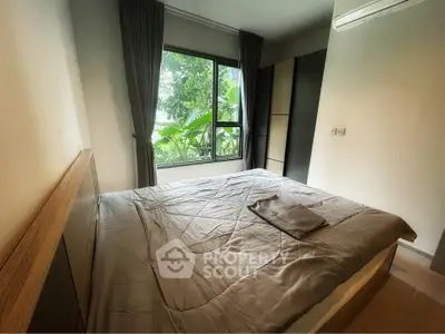 Cozy bedroom with large window and lush greenery view, featuring modern decor and ample natural light.