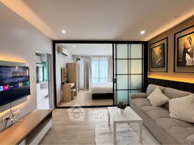 Modern open-plan living room with stylish decor and sliding glass doors to bedroom