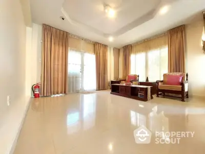 Spacious living room with glossy tiled flooring, elegant drapery, and ample natural light streaming through large windows, perfect for luxurious living.