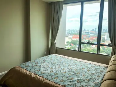 Spacious bedroom with large window offering stunning city view
