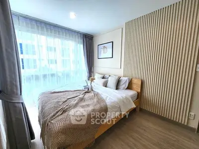 Modern bedroom with stylish decor and large window for natural light.