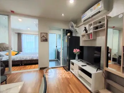 Modern apartment interior with open living room and bedroom, featuring stylish decor and wooden flooring.