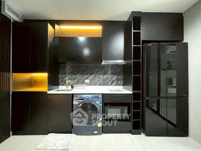 Modern kitchen with sleek black cabinets, built-in appliances, and ambient lighting