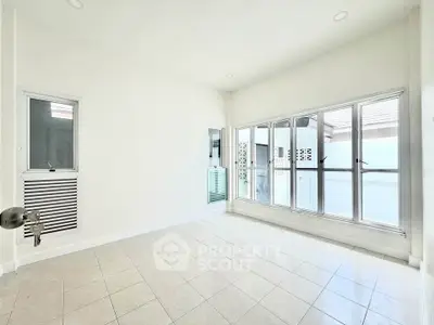 Bright and spacious room with large windows and tiled floor, perfect for customization.