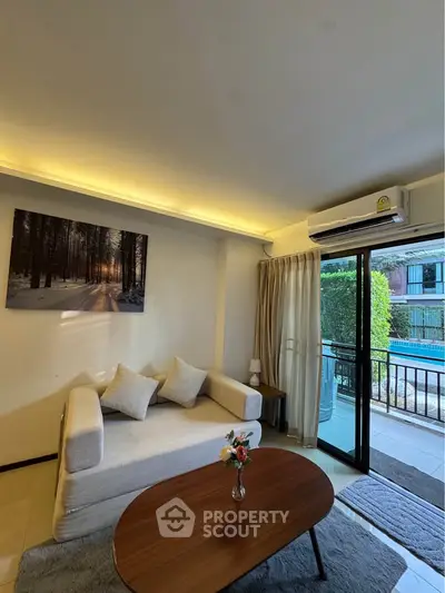 Cozy living room with modern sofa, pool view, and natural light through sliding glass doors.