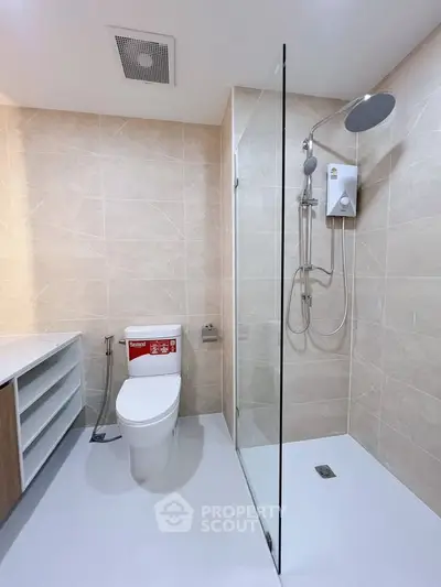 Modern bathroom with glass shower and sleek fixtures in a contemporary home.