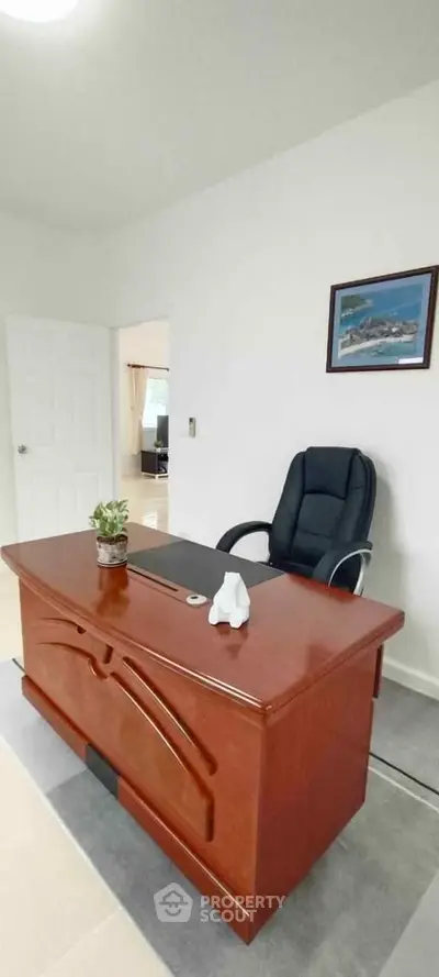 Elegant home office with wooden desk and leather chair, perfect for productivity.