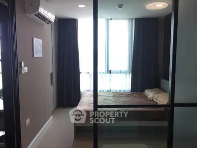 Modern bedroom with large windows and air conditioning in a stylish apartment.