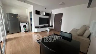 Modern living room with sleek furniture and integrated kitchen appliances in a stylish apartment.