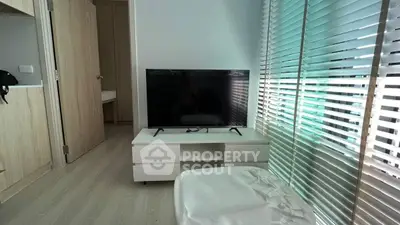 Modern living room with sleek TV setup and stylish blinds