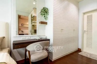 Modern bedroom with stylish furniture and built-in wardrobe, featuring a cozy chair and elegant decor.