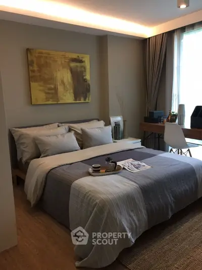 Modern bedroom with stylish decor and natural light, featuring a cozy bed and a functional workspace.