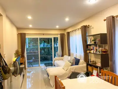 Spacious living room with cozy seating and garden view, perfect for relaxation and entertaining.