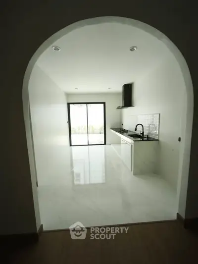 Modern kitchen with sleek design and open layout, featuring large sliding glass doors for natural light.