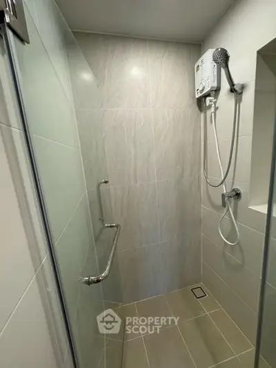Modern bathroom with sleek shower design and wall-mounted water heater.