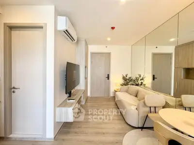 Modern living room with sleek design, featuring a wall-mounted TV, air conditioning, and stylish furniture.