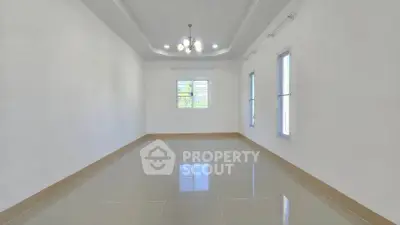 Spacious empty room with glossy tiled floor and modern ceiling lights.
