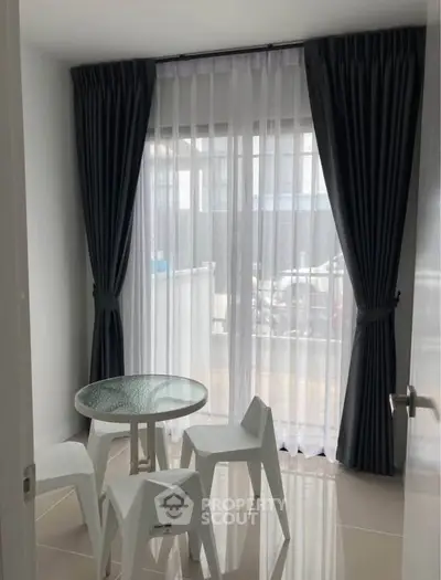 Cozy small dining area with glass table and modern chairs by window