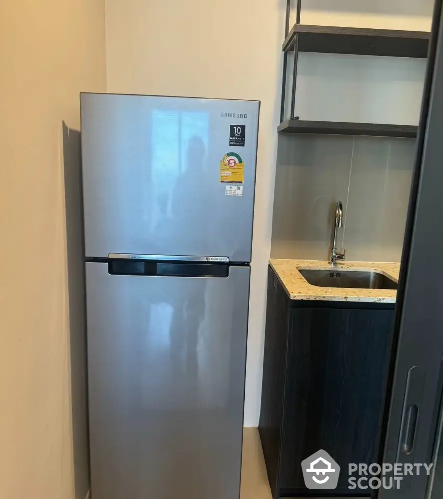 Modern kitchen corner with sleek fridge and compact sink area