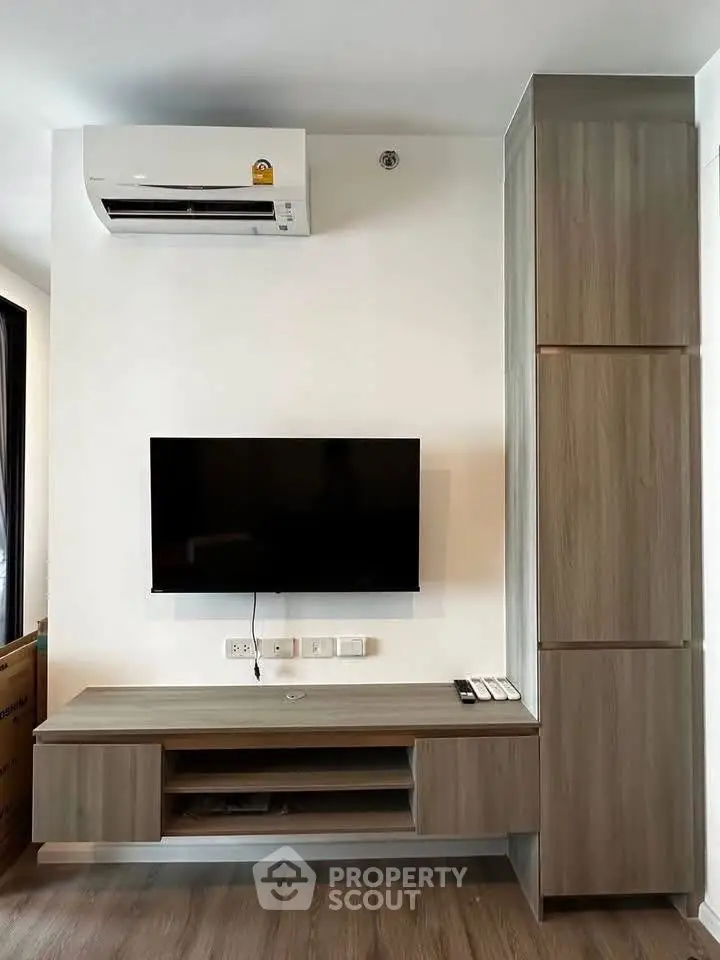 Modern living room with sleek TV unit and air conditioning, perfect for urban living.