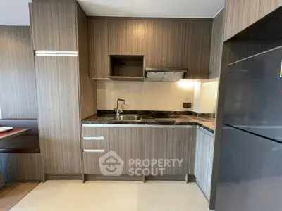 Modern compact kitchen with sleek wooden cabinets and built-in appliances