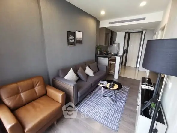 Modern living room with stylish furniture and open kitchen layout in a cozy apartment.