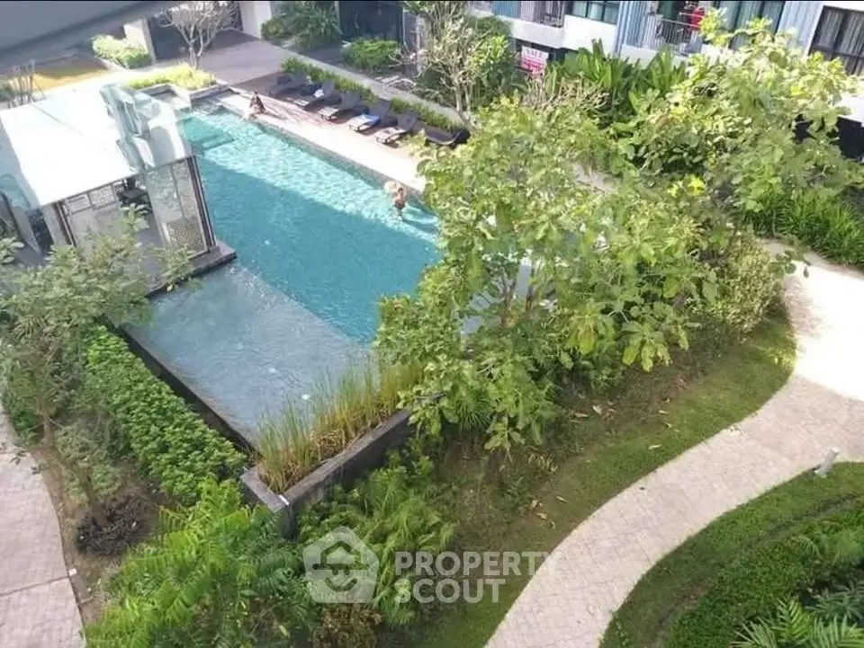 Luxurious apartment complex with a stunning outdoor pool and lush greenery, perfect for relaxation.