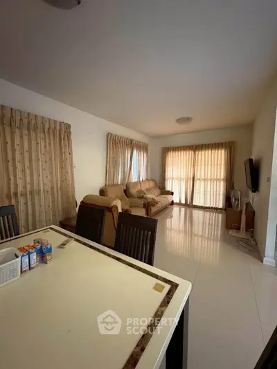Spacious living room with elegant curtains and comfortable seating, perfect for relaxation and entertainment.